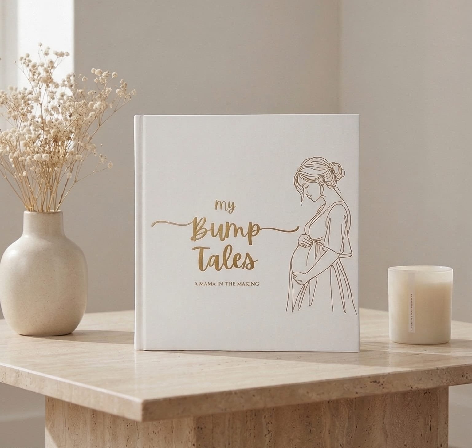My Bump Tales pregnancy journal standing on marble table with flowers and candle